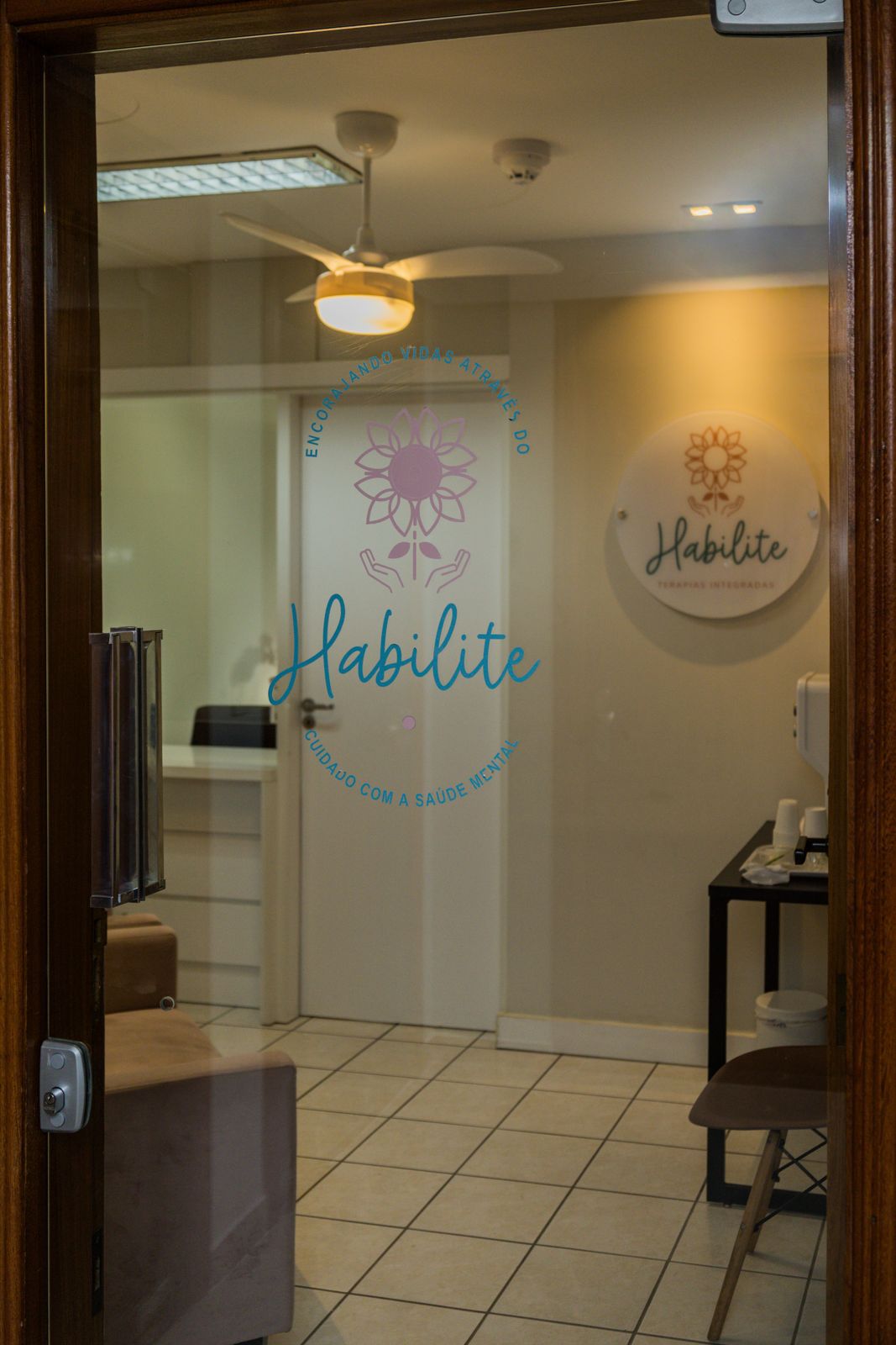 Entrada da clínica com o logotipo Habilite na porta de vidro